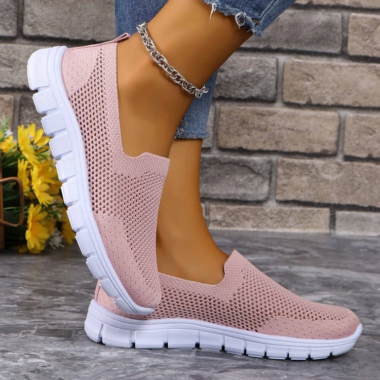 Unique Kulture Breathable Mesh Round Toe Slip-Ons featuring a lightweight and breathable mesh upper in a stylish design. The slip-ons are displayed in a casual setting, highlighting their comfortable flat heel and versatile appeal for everyday wear.
