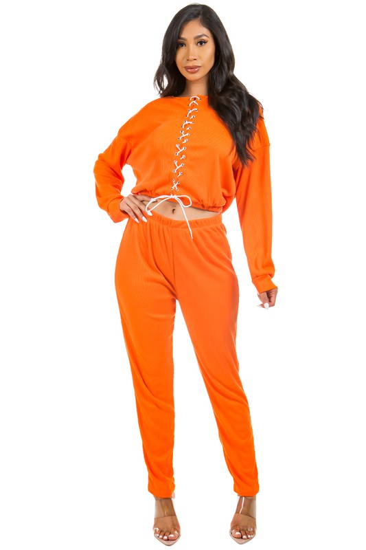 Model wearing Unique Kulture luxury two piece pant set with multi-strip top and elastic waist pants

 orange
