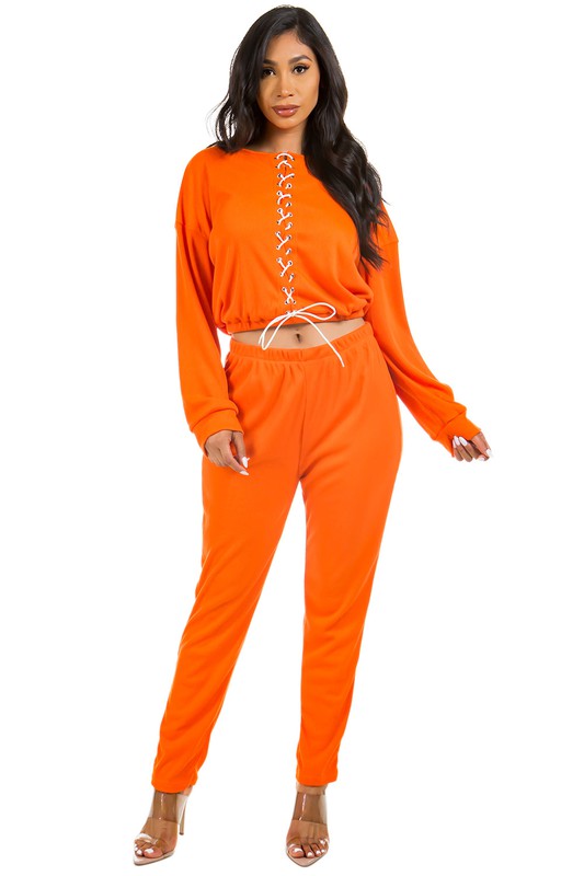 Model wearing Unique Kulture luxury two piece pant set with multi-strip top and elastic waist pants

 orange