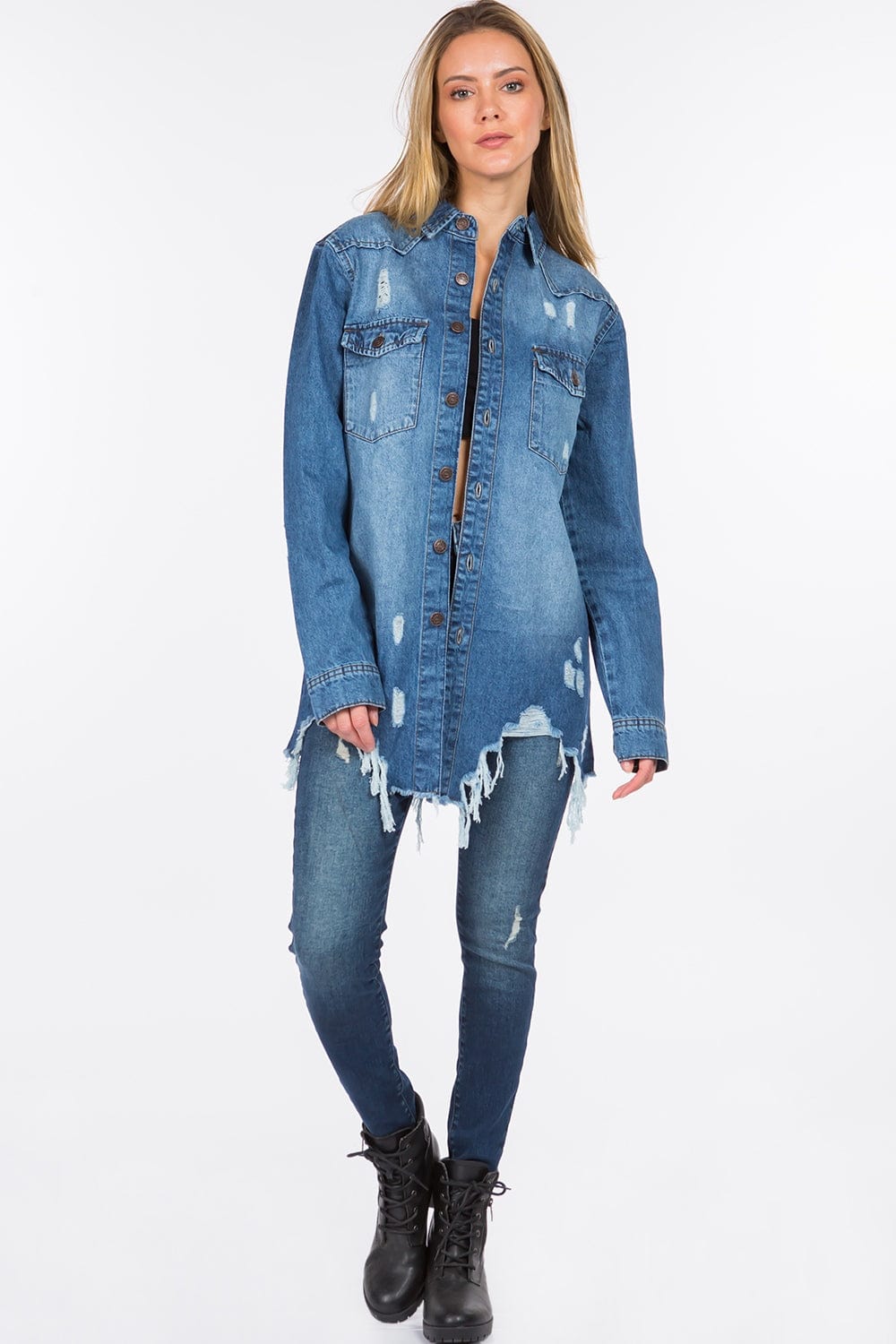 Unique Kulture Distressed Frayed Hem Denim Jacket featuring a classic denim silhouette with distressed detailing and a raw frayed hem. The jacket is shown in a stylish, casual setting, highlighting its edgy design and versatility for layering over various outfits
