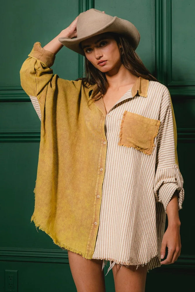 Model wearing a washed raw hem oversized shirt from Unique Kulture, featuring distressed fabric, buttoned front, and pocket details.

 close up 