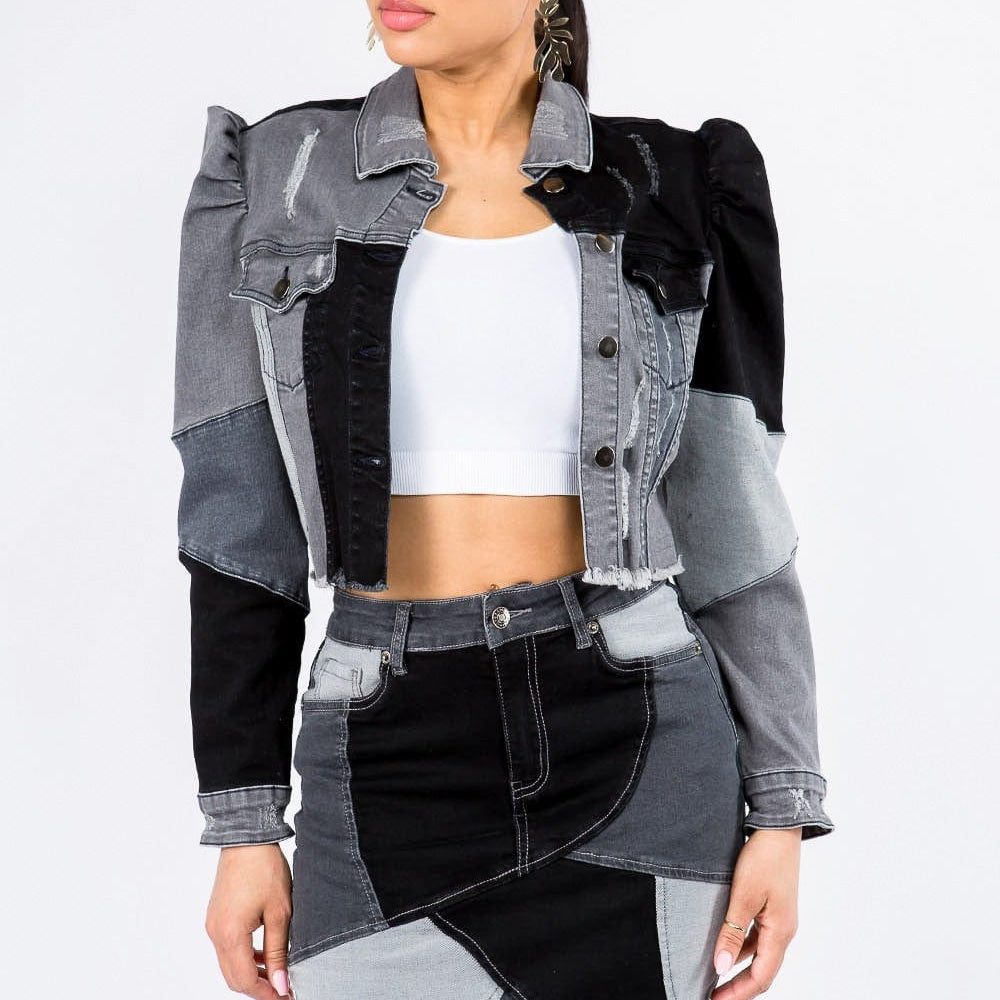 ront view of the Unique Kulture American Bazi Button Up Cropped Patchwork Denim Jacket, featuring a stylish cropped length, distinctive patchwork design, frayed edge hem, and puff shoulder trims. The jacket showcases a button front closure, perfect for adding a trendy and eye-catching element to any outfit.
