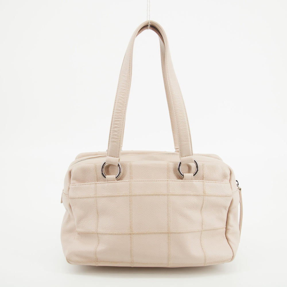 Beige quilted handbag on a white background