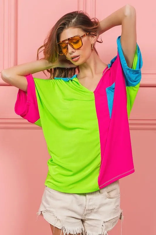 Woman wearing a BiBi Slinky Knit Color Block V Neck Top with oversized fit and pocket detail, in bold modern colors, perfect for casual or dressy occasions.

