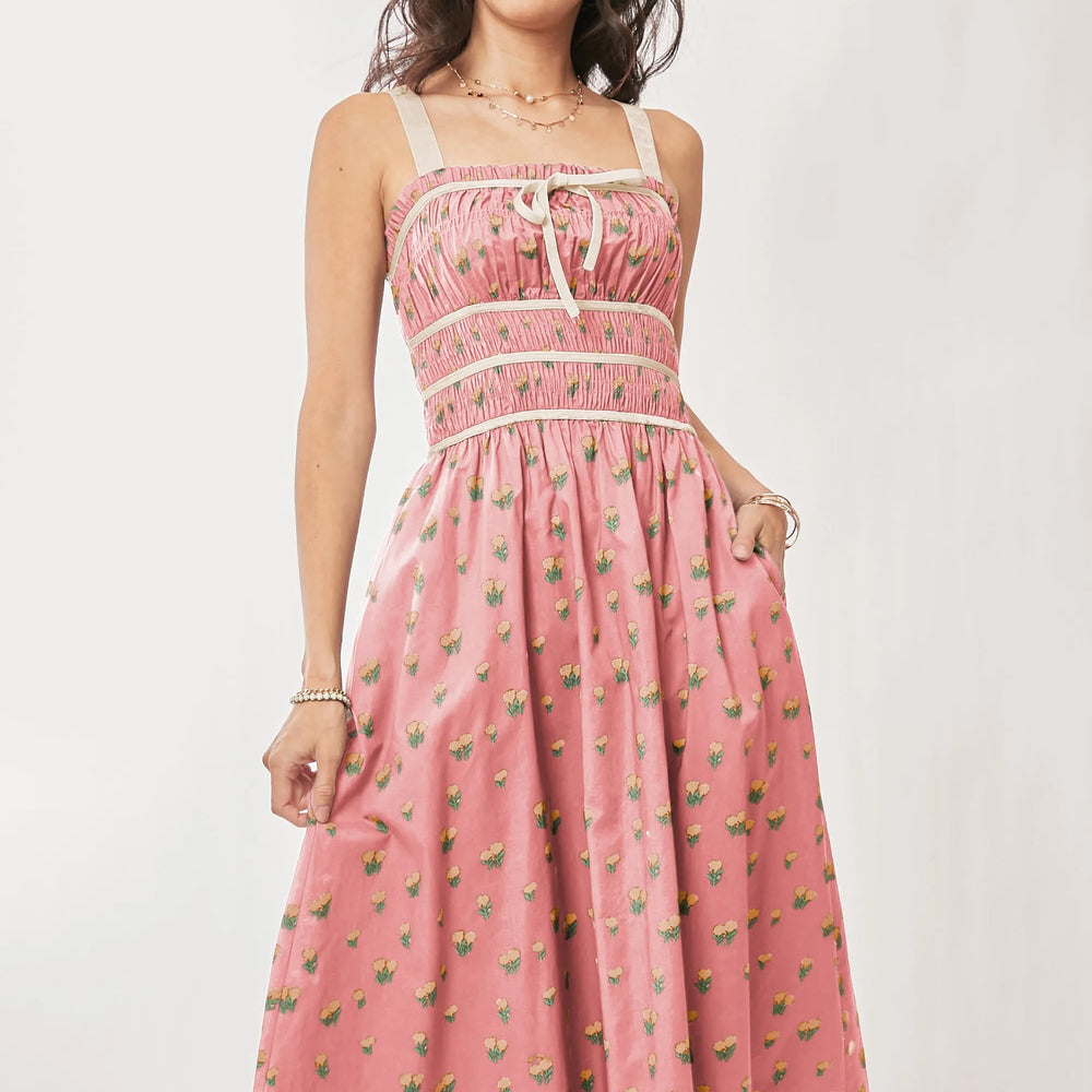 Model wearing a midi dress with contrast velvet tape detail and a smocked bodice from Unique Kulture, featuring elegant velvet accents and a flowing silhouette.


