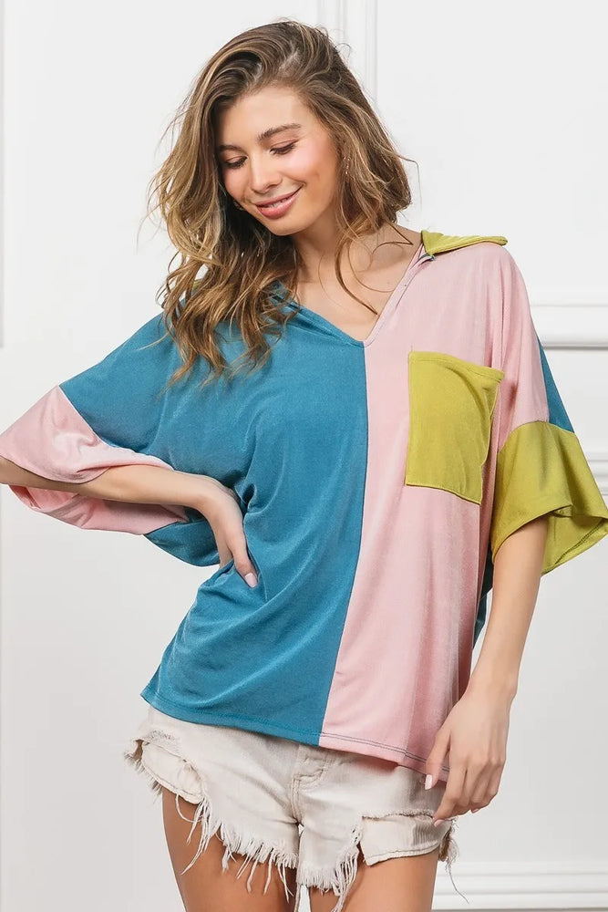 Woman wearing a BiBi Slinky Knit Color Block V Neck Top with oversized fit, bold color blocking, and pocket detail-perfect for modern, casual, or dressy occasions