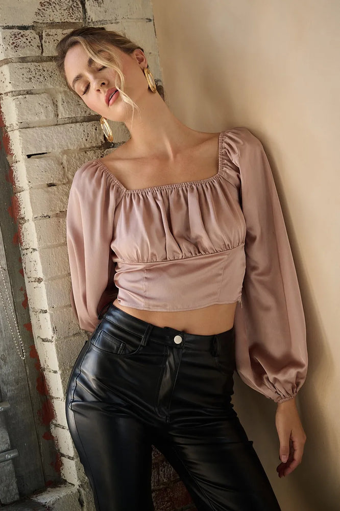 Woman wearing a Mittoshop Satin Square Neck Blouse with a chic square neckline and feminine sleeves, styled for a polished, elegant look.

