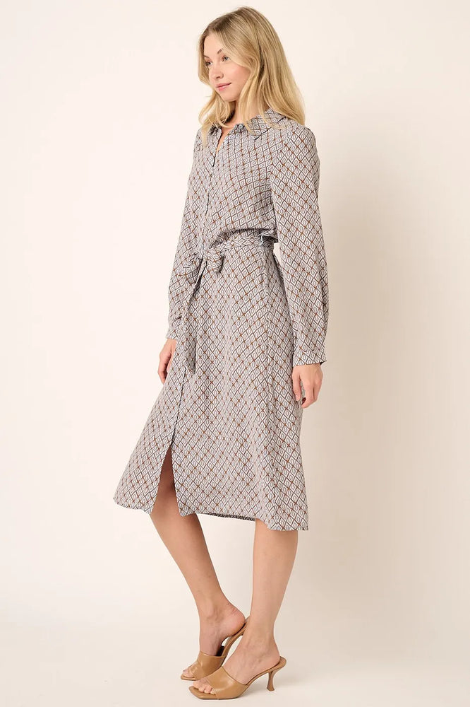 Model wearing an abstract print waist tie midi shirt dress from Unique Kulture, featuring a buttoned front, collared neckline, and a bold, modern print.

 close view
 close up 