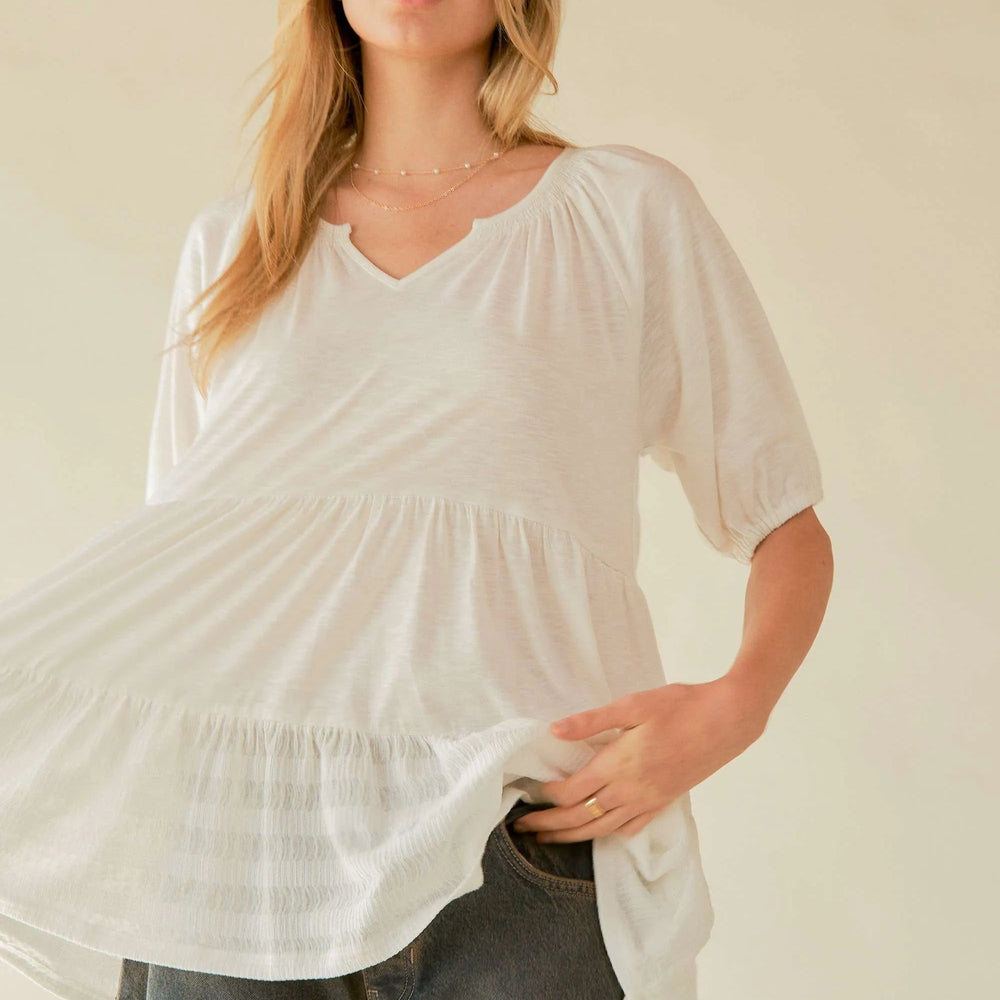 Woman wearing an eco-friendly V-neck tiered blouse from Unique Kulture, featuring lightweight, breathable fabric and a comfortable, flowy design women posing 
