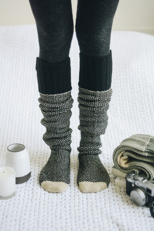 Model wearing Unique Kulture luxury knitted lounge socks, knee high, open-work design

 black tan
