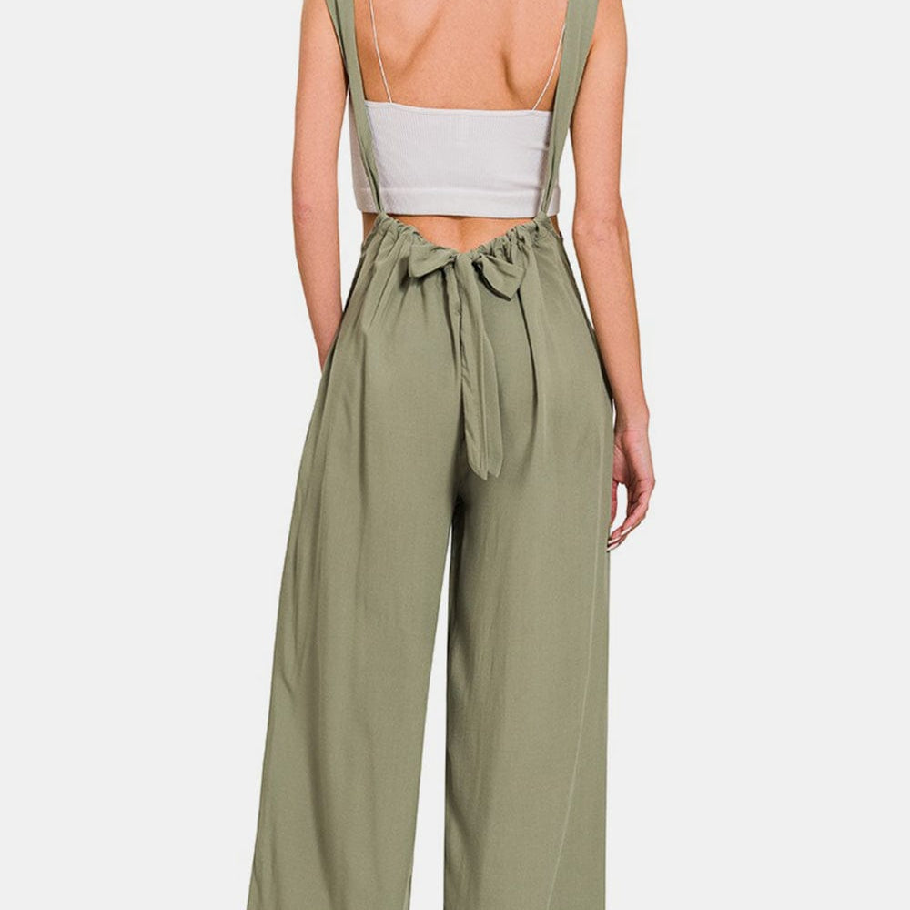  Unique Kulture Designer Zenana Pocketed Wide Strap Wide Leg Overalls. The overalls feature wide straps and wide legs, offering a relaxed and comfortable fit. The overalls also include functional pockets for added convenience. This versatile garment exudes a casual yet stylish vibe, perfect for a variety of occasions