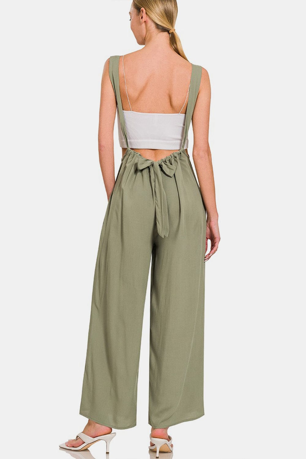  Unique Kulture Designer Zenana Pocketed Wide Strap Wide Leg Overalls. The overalls feature wide straps and wide legs, offering a relaxed and comfortable fit. The overalls also include functional pockets for added convenience. This versatile garment exudes a casual yet stylish vibe, perfect for a variety of occasions