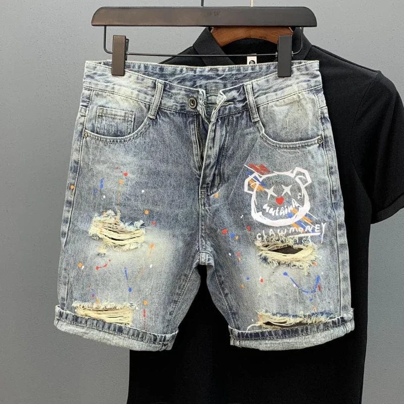 A pair of Unique Kulture Claw Monkey Designer Jean Shorts displayed against a plain background. The shorts are made from high-quality denim, featuring a stylish distressed look with intricate stitching. A unique claw monkey graphic is prominently displayed, adding a bold and playful touch. The shorts have a modern, tailored fit with front and back pockets, and a button and zip closure.