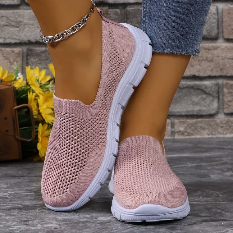 Unique Kulture Breathable Mesh Round Toe Slip-Ons featuring a lightweight and breathable mesh upper in a stylish design. The slip-ons are displayed in a casual setting, highlighting their comfortable flat heel and versatile appeal for everyday wear.
