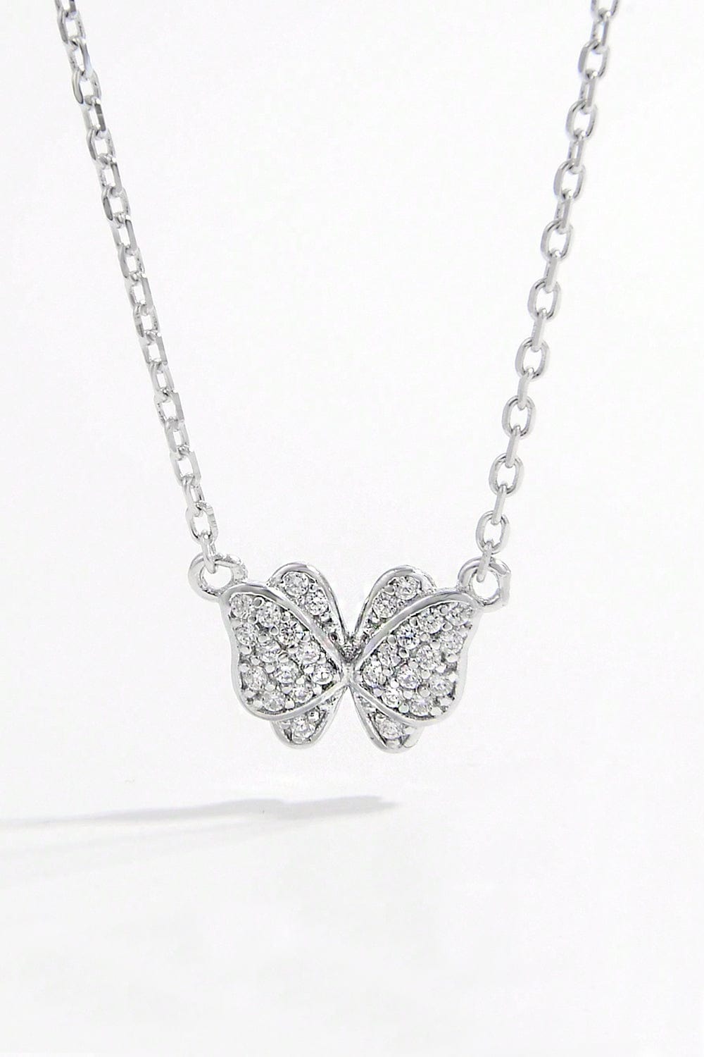 925 Sterling Silver Zircon Butterfly Pendant Necklace. The pendant is crafted in the shape of a butterfly and adorned with sparkling zircon gemstones. The necklace chain complements the pendant, showcasing its delicate beauty. This accessory exudes elegance and charm, perfect for adding a touch of sophistication to any outfit.