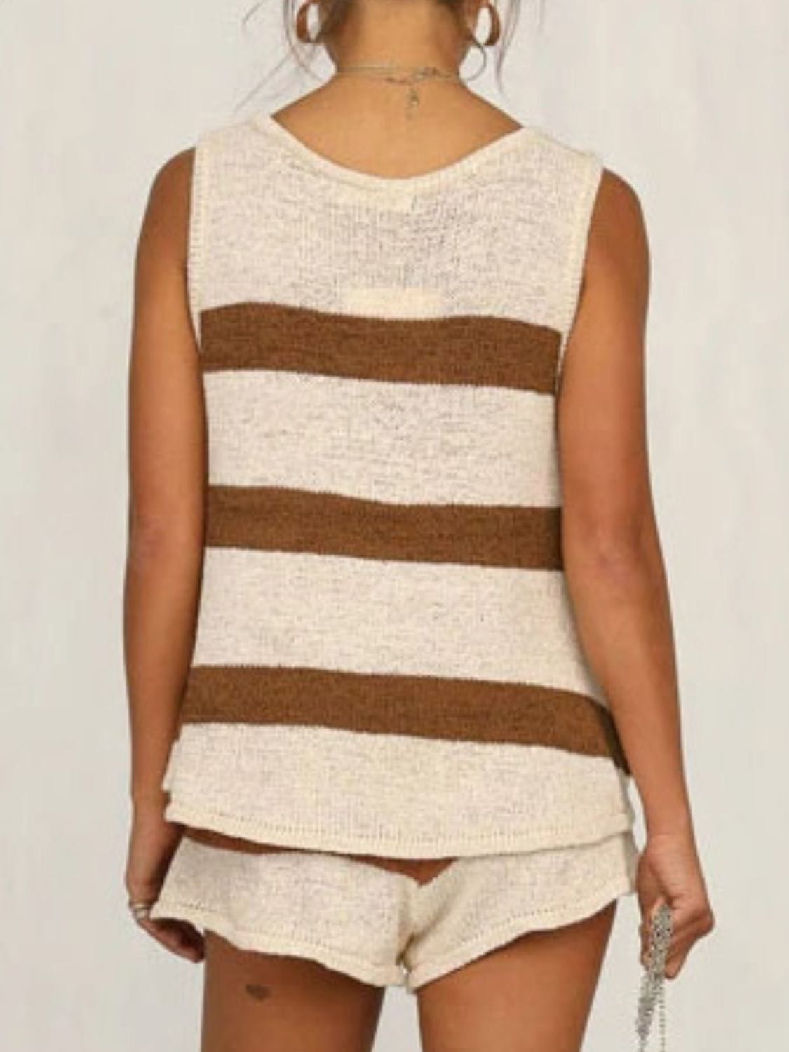 : A stylish two-piece sweater set featuring a V-neck sleeveless top in a soft fabric paired with drawstring shorts. The outfit is displayed on a neutral background, showcasing its comfortable and casual design, perfect for summer wear. The top highlights a flattering neckline, while the shorts feature an adjustable drawstring for a customizable fi