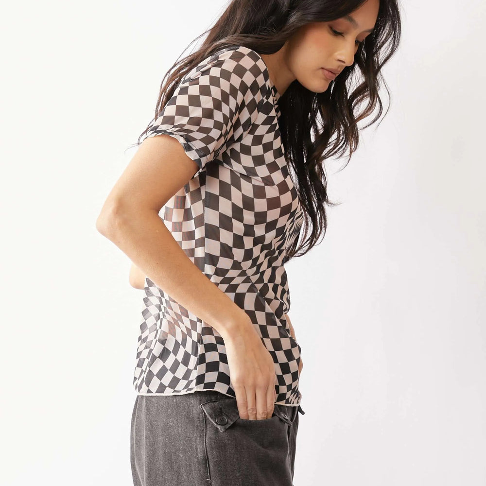 Model wearing a brown and white checkerboard mesh short sleeve top from Unique Kulture, featuring a mock neck and semi-sheer, stretchy fabric.

 side view