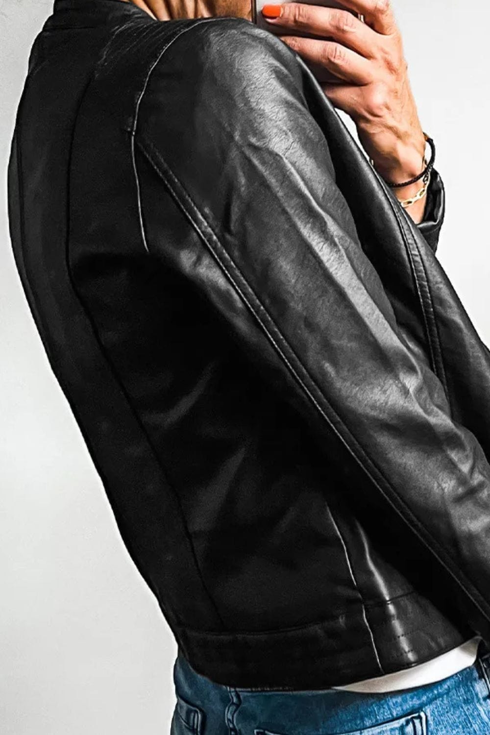 side view of the Unique Kulture PU Leather Round Neck Long Sleeve Jacket, featuring a sleek design made from 100% PU leather. The jacket includes a round neckline, long sleeves, and practical pockets, with a lined interior for added comfort and warmth