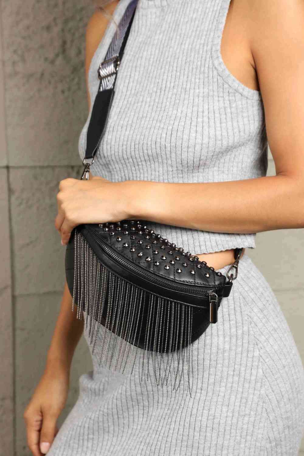 Alt text for an image of the "Adored PU Leather Studded Sling Bag with Fringes" might be:  "An elegant black PU leather sling bag adorned with studs and fringes, perfect for adding a touch of style and sophistication to any outfit."