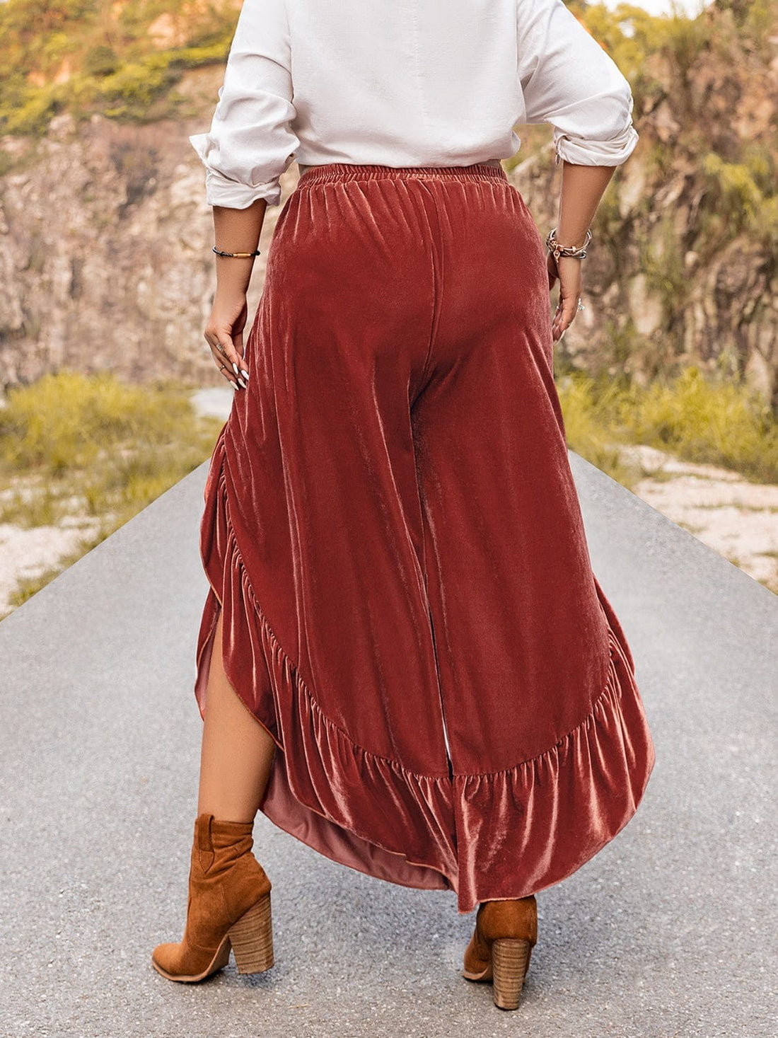 "Image: A model wearing Unique Kulture Plus Size Ruffled Slit Pants. The pants are a stylish and trendy addition to plus-size fashion, featuring a high waist with ruffled detailing and a thigh-high slit on one leg. The design is both flattering and fashionable, perfect for a confident and chic look."