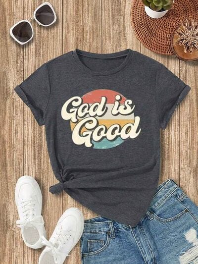 A stylish women's shirt in soft fabric featuring a minimalist design with the phrase 'God is Good' gracefully printed in elegant font. The shirt showcases a blend of comfort and faith-inspired fashion, perfect for expressing positivity and gratitude in a contemporary and chic way."