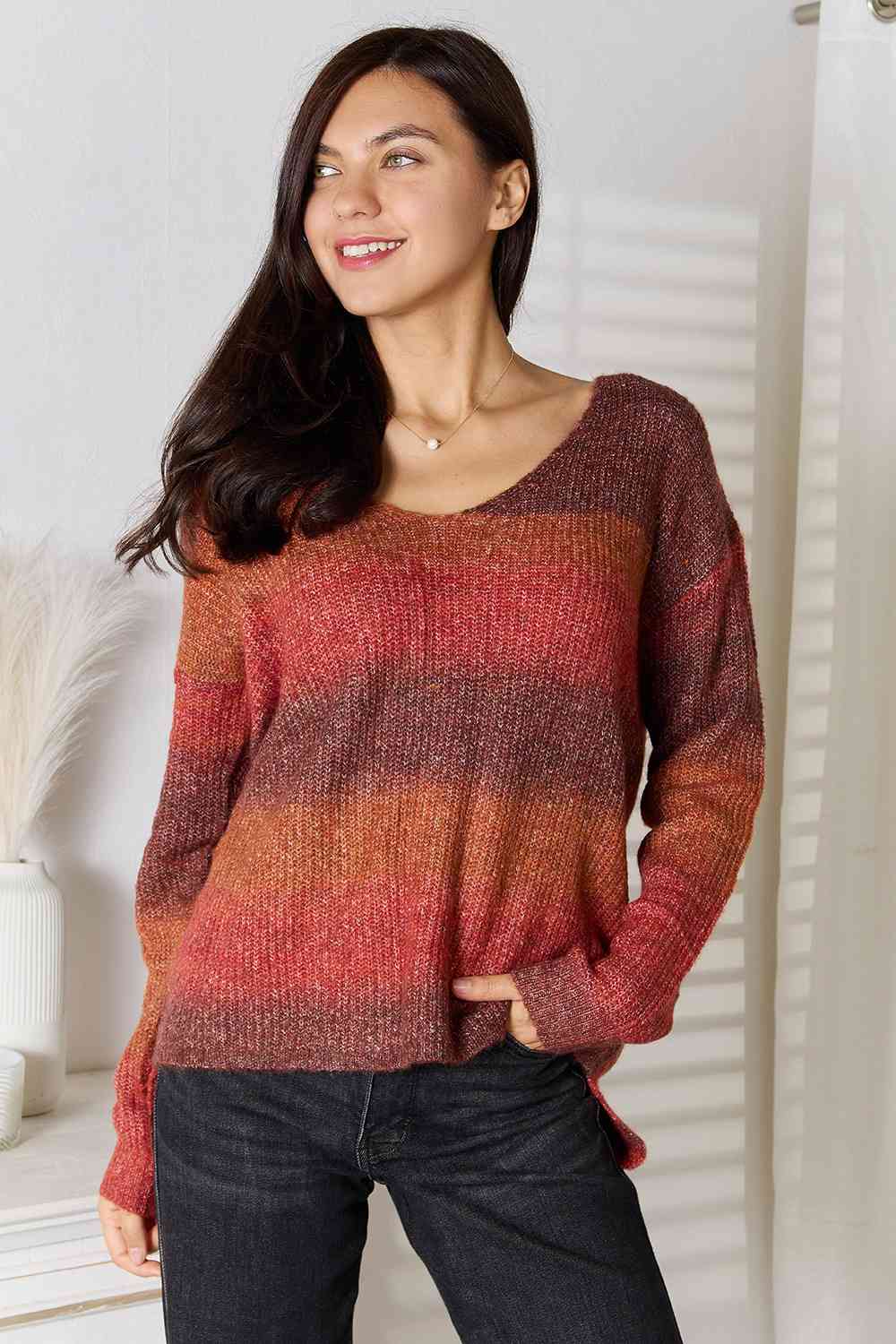 "Image: A model wearing a stylish Unique Kulture Gradient V-Neck Sweater. The sweater features a beautiful gradient pattern with shades of blue and gray transitioning from the top to the bottom. The V-neck design adds a touch of elegance to the overall look."