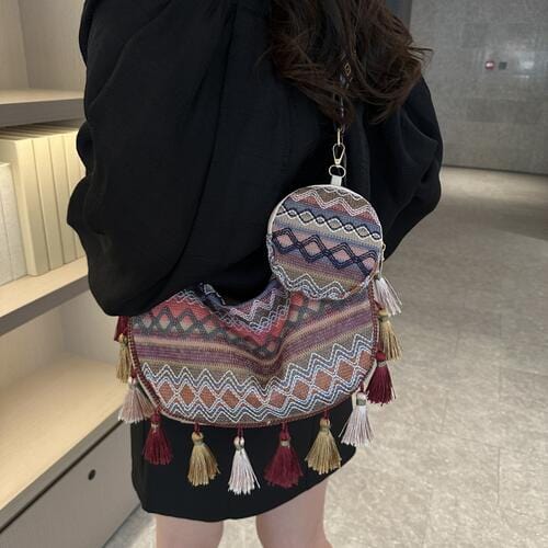 "Image: A vibrant and stylish Unique Kulture designer crossbody bag featuring intricate printed patterns and tassel details. The bag includes a small purse, showcasing a mix of colors and textures in a compact, fashionable accessory."
