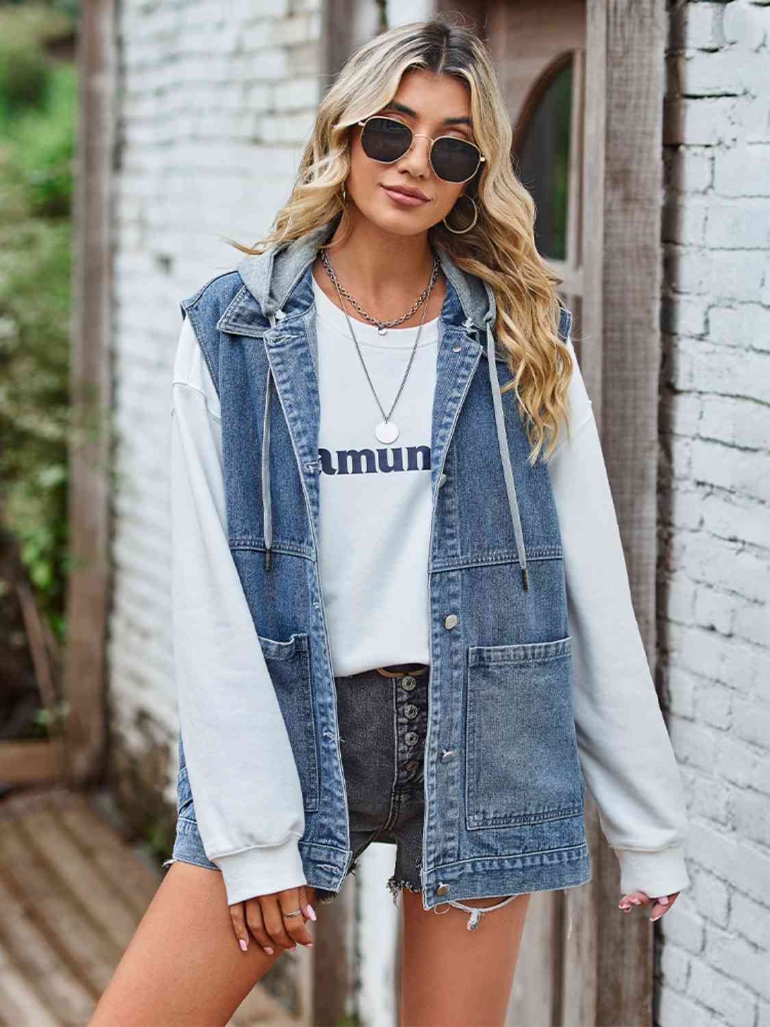 "Image of a unique Kulture designer button-up sleeveless denim jacket with pockets. The jacket features a modern and stylish design with a button-down front, sleeveless cut, and two functional pockets. The denim fabric is distressed and faded, giving it a trendy and vintage-inspired look. Perfect for adding a touch of casual yet fashionable style to any outfit."