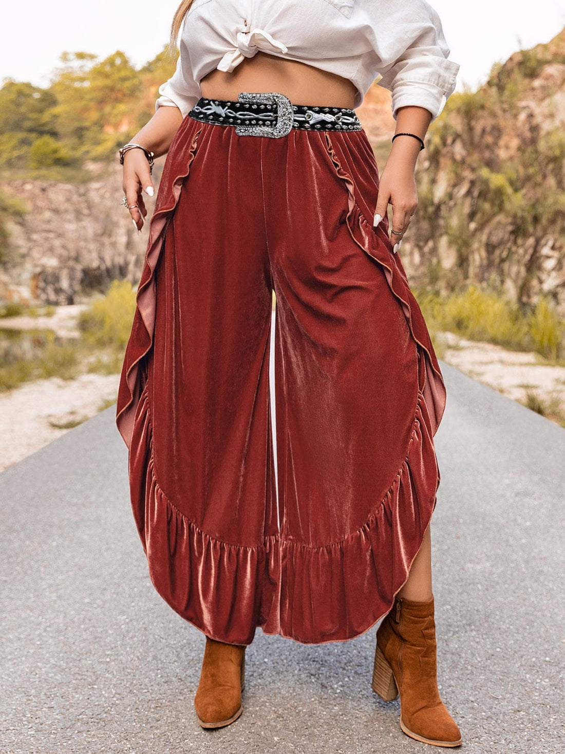 "Image: A model wearing Unique Kulture Plus Size Ruffled Slit Pants. The pants are a stylish and trendy addition to plus-size fashion, featuring a high waist with ruffled detailing and a thigh-high slit on one leg. The design is both flattering and fashionable, perfect for a confident and chic look."