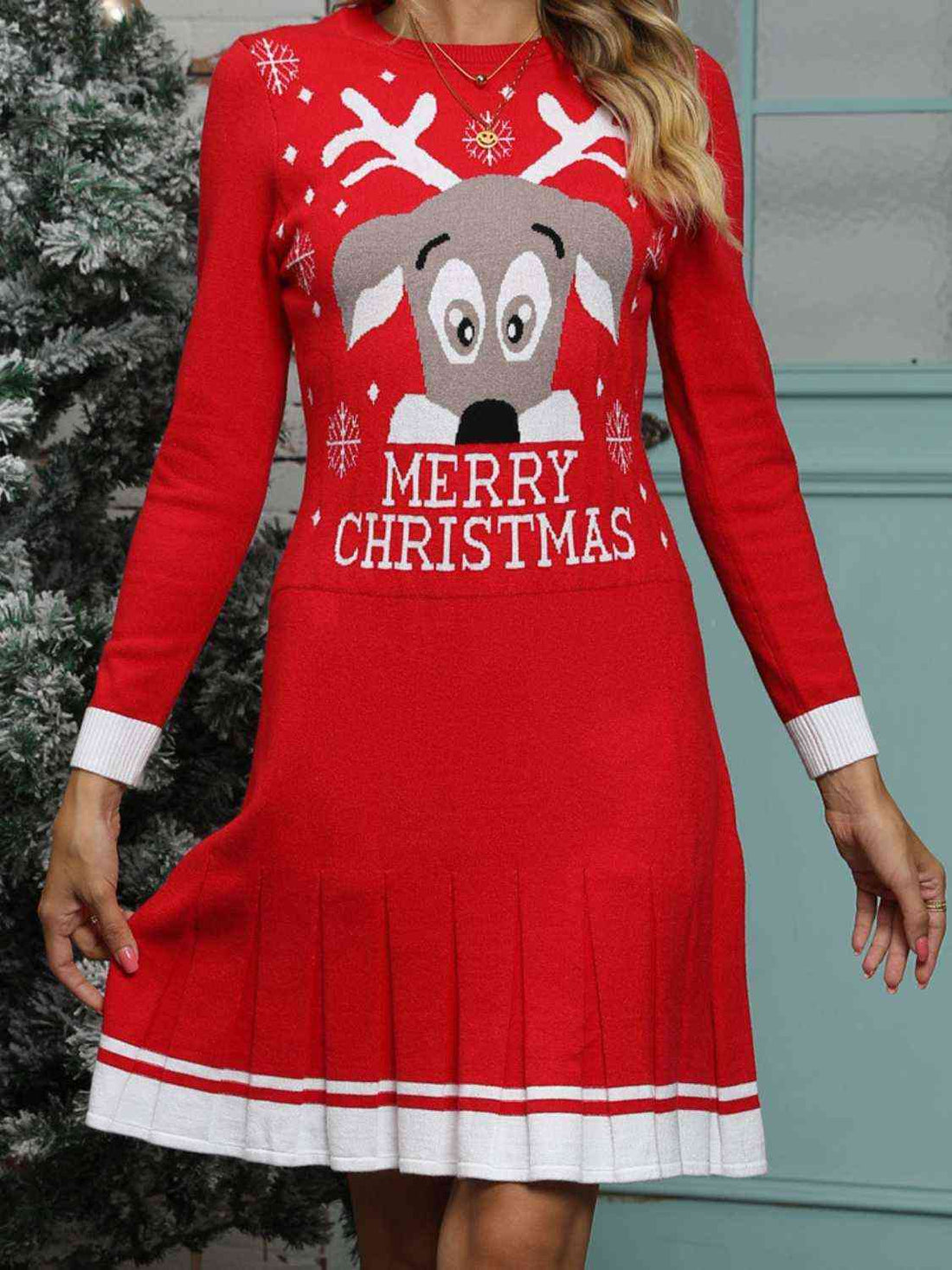A festive holiday sweater dress by Unique Kulture featuring a Merry Christmas graphic design with pleated detailing."