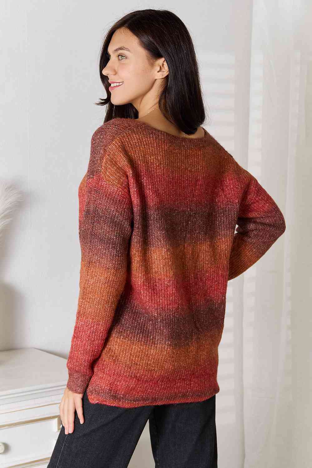 "Image: A model wearing a stylish Unique Kulture Gradient V-Neck Sweater. The sweater features a beautiful gradient pattern with shades of blue and gray transitioning from the top to the bottom. The V-neck design adds a touch of elegance to the overall look."